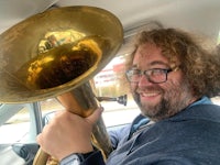 a man in a car holding a tuba