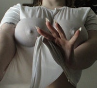 a woman posing in a white shirt with big tits