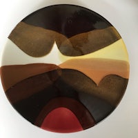 a plate with a black, brown, and red design