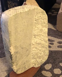 a piece of cheese on a wooden stand