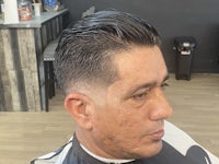 a man sitting in a barber shop with his hair cut