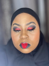 a woman wearing a black hijab and red lipstick