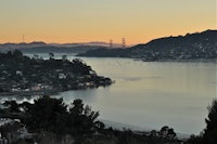 a view of the golden gate bridge from a hill overlooking a body of water