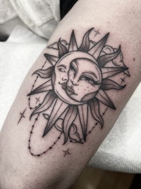 a tattoo of a sun and moon on a woman's thigh