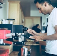 a man using an espresso machine in a kitchen