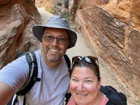 a man and woman taking a selfie in a narrow canyon