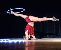 a woman doing a hula hoop on stage