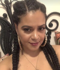 a woman with long braids posing for a photo