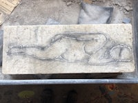 a stone slab with a drawing of a woman laying on it