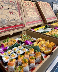 japanese food in boxes on a conveyor belt