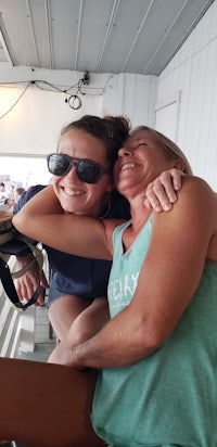 two women hugging on the deck of a boat