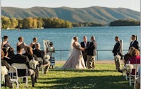 a wedding ceremony at a lake with mountains in the background
