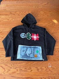 a black hoodie with a peace symbol on it
