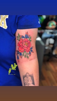 a woman's arm with a tattoo of a red rose