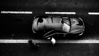 a black and white photo of a car on the street