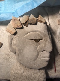 a statue of a head with a blue cloth covering it
