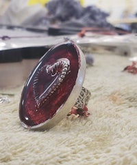 a ring with a red heart on it