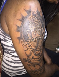 a woman with a tattoo of a ganesh on her arm