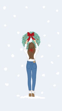 a girl holding a wreath in the snow
