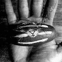 a black and white photo of a hand holding a rock