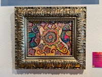 a framed painting of a psychedelic painting on a wall