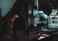 a man with dreadlocks working in a recording studio