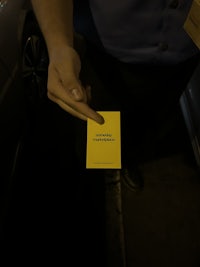 a person holding a yellow business card
