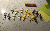 origami paper birds on a table next to a bottle of lip balm
