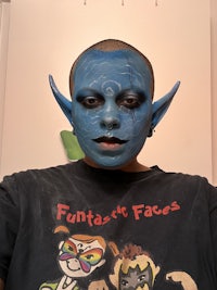a man with a blue elf face painted on his face