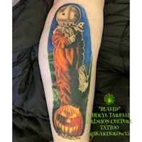 a tattoo of a scarecrow on a leg