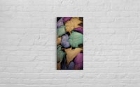 a picture of colorful leaves hanging on a brick wall