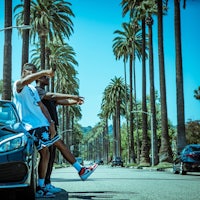 two men standing next to a car