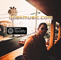 a man is standing on a balcony with the words quick music com