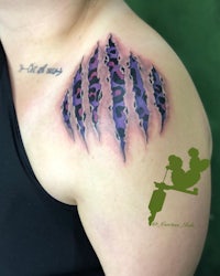 a woman with a purple and black tattoo on her shoulder