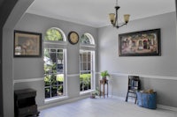 an entryway with a clock and framed pictures