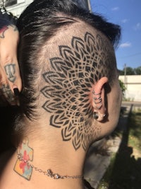 a woman with a mandala tattoo on her head