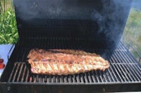 ribs on a grill with smoke coming out of it