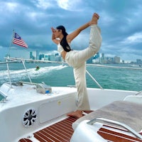 a woman doing yoga on a boat in miami