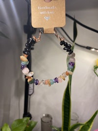 a bracelet with multi colored stones and a tag on it
