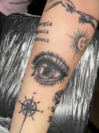 a tattoo with a compass, eye, and compass
