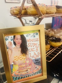 a framed picture of a woman eating donuts