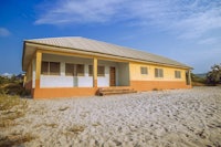 a yellow and orange building on the sand