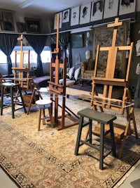 a room with several easels and chairs