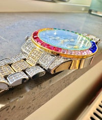 a rainbow colored watch sitting on a counter top