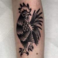 a black and white rooster tattoo on the forearm