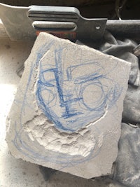 a drawing of a face on a piece of concrete