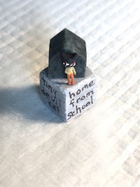 a small figurine sitting on top of a piece of paper