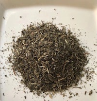 a pile of dried herbs on a white plate