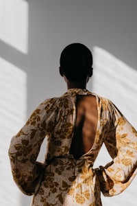 the back of a woman in a yellow floral dress