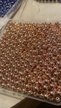 a tray of copper beads on a table